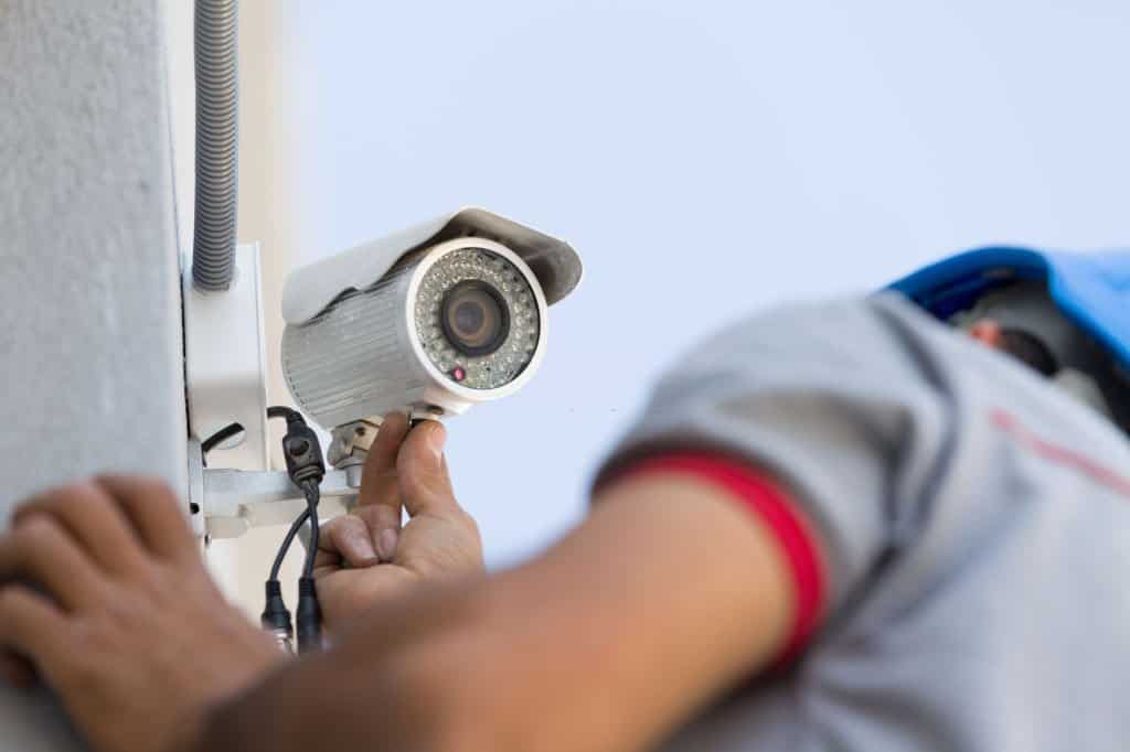 Security camera service man working with the closeup on the security cam